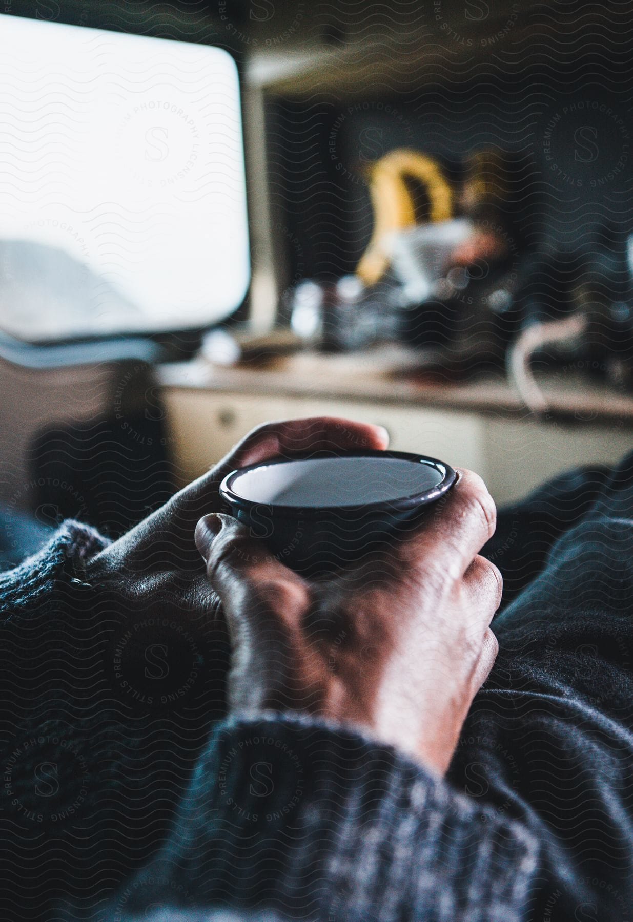 A man sitting in a kitchen drinking coffee