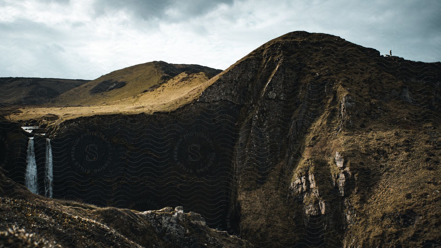 A stream falling into the valley between hills