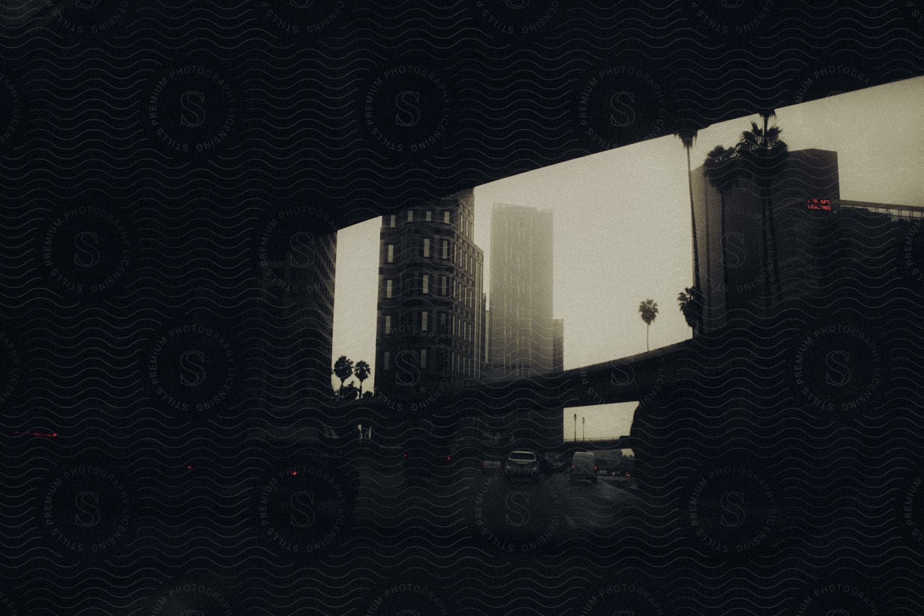 Wide shot of city detail from inside a dark tunnel showing cars and buildings around in los angeles