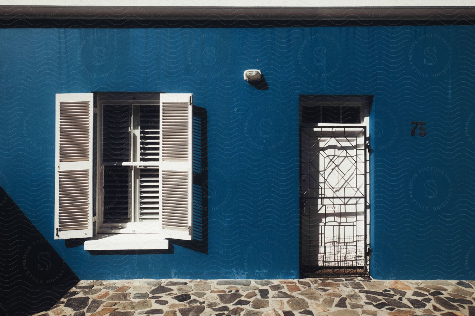 A blue building with a white door and a window with white shutters in south africa