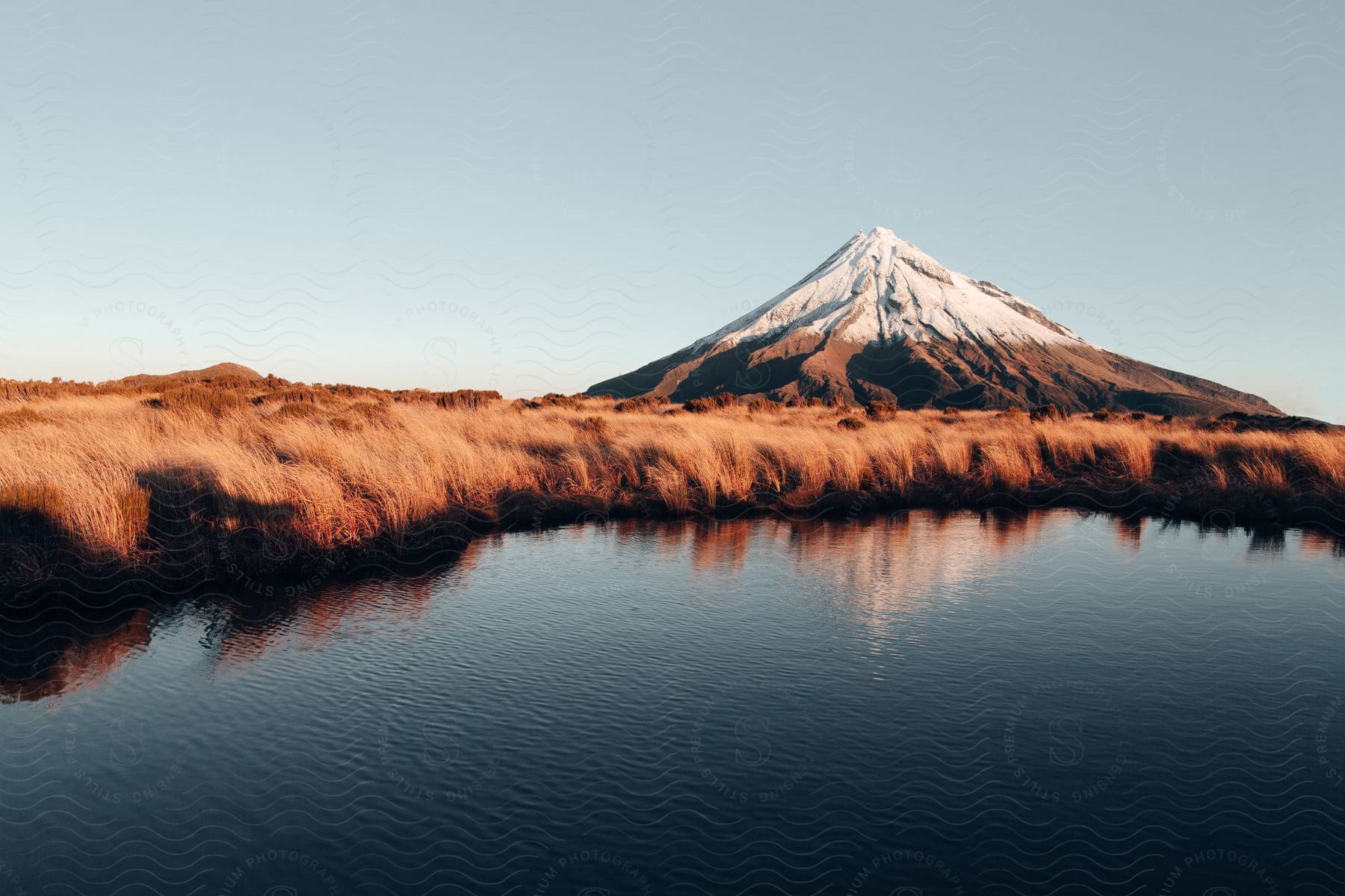 A serene natural landscape with mountains highlands and a lake surrounded by clouds