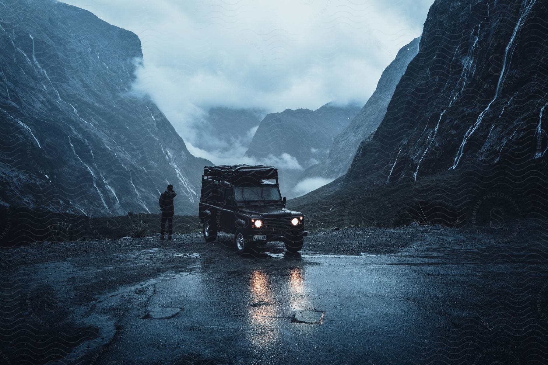 A person driving a car near water and mountains in new zealand