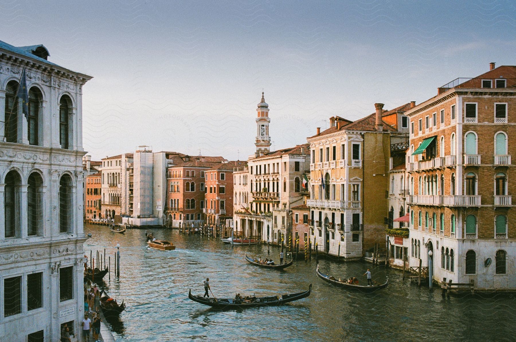 River city with numerous residential buildings and people enjoying canoeing in the river