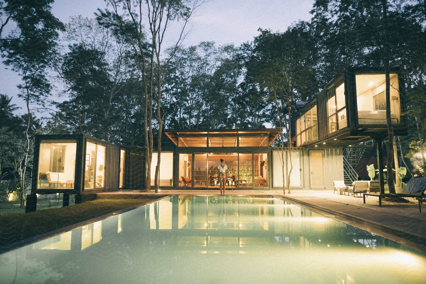 A woman stands in the backyard of her modern style home