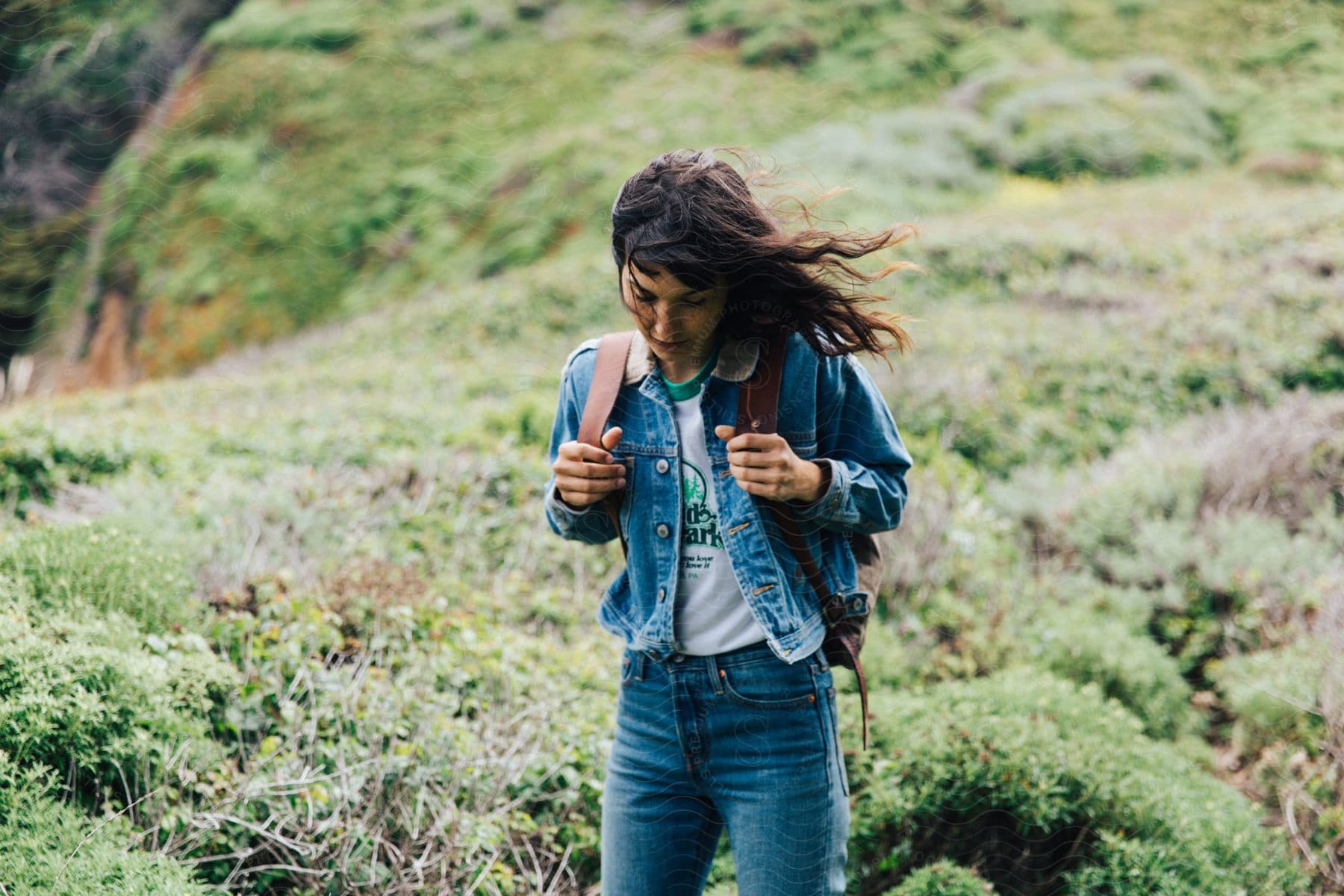 A female is hiking through the wilderness