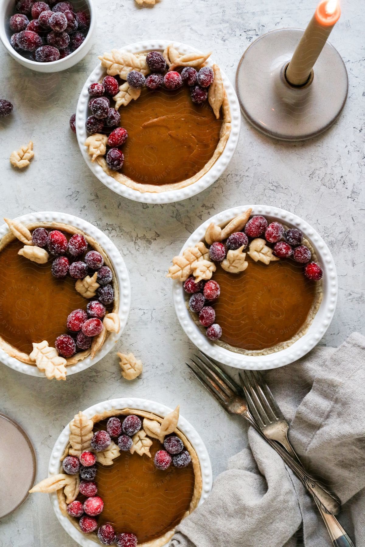 Mini vegan pumpkin pies with frosted cranberries on a plate