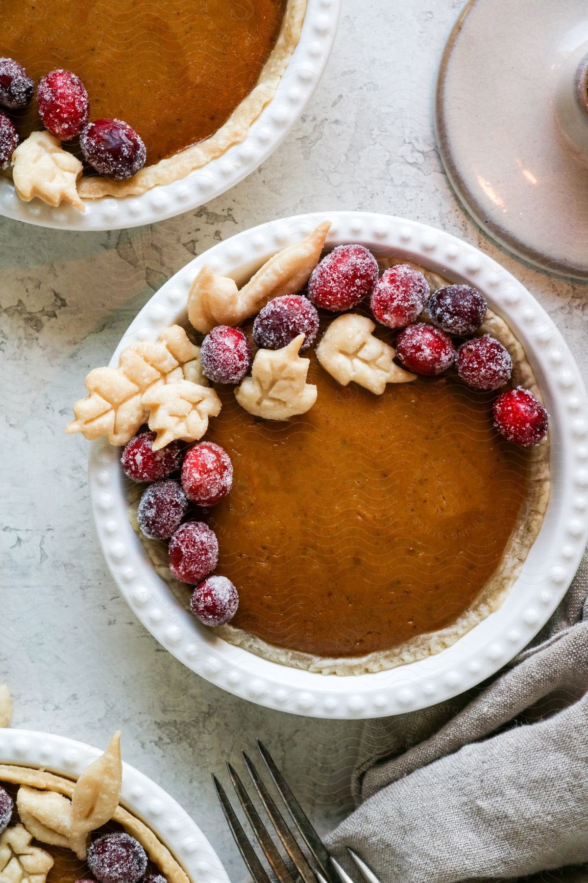 A fresh baked pumpkin pie with leaf crust pieces and frozen grapes