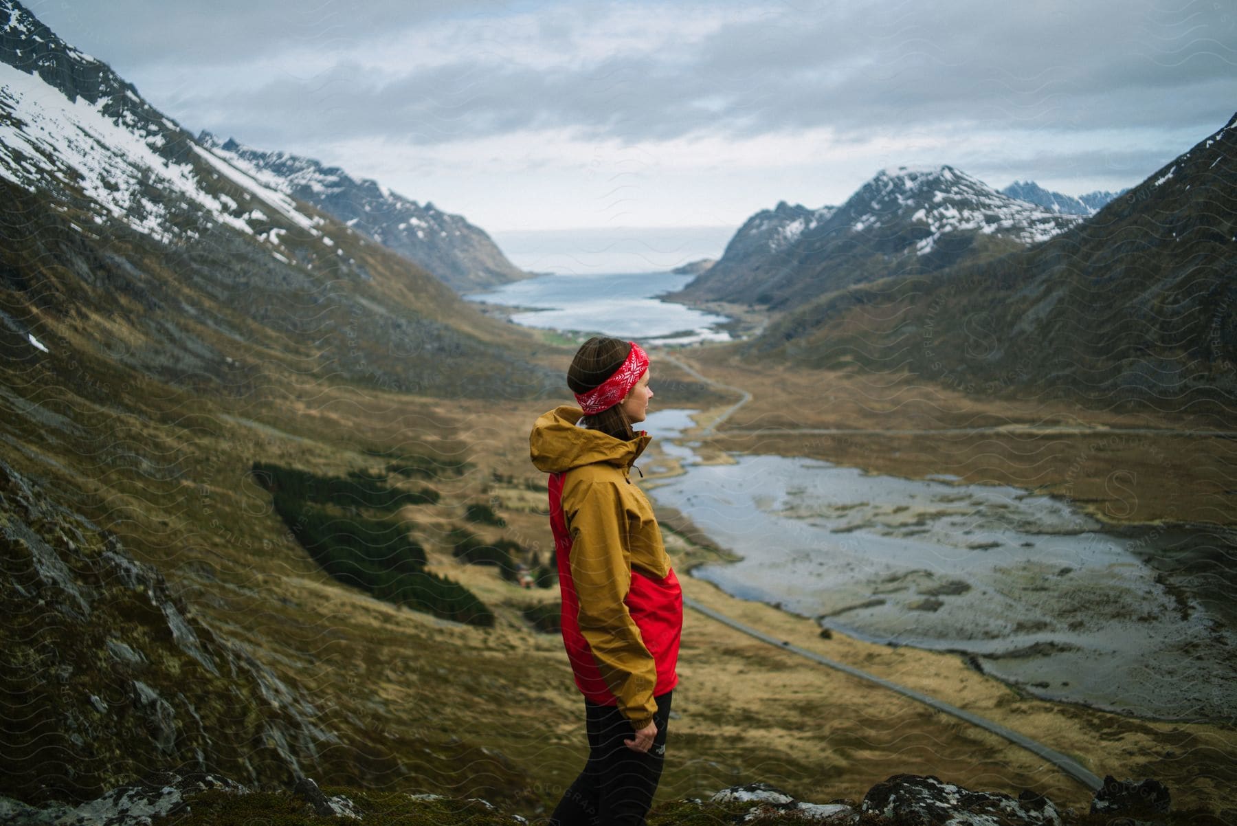 A woman hiking outdoors on a cloudy day in lofoten norway