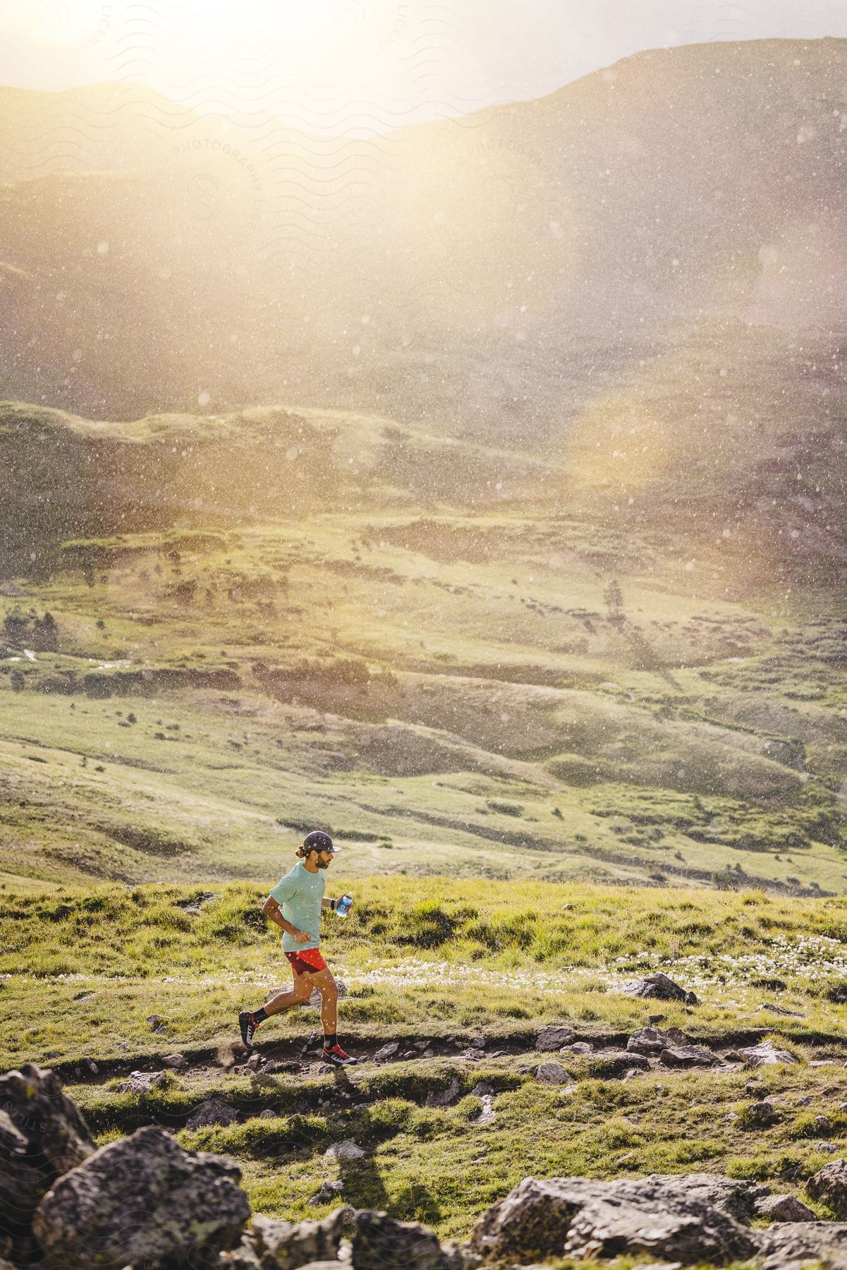 A man jogs through a rocky field near a canyon