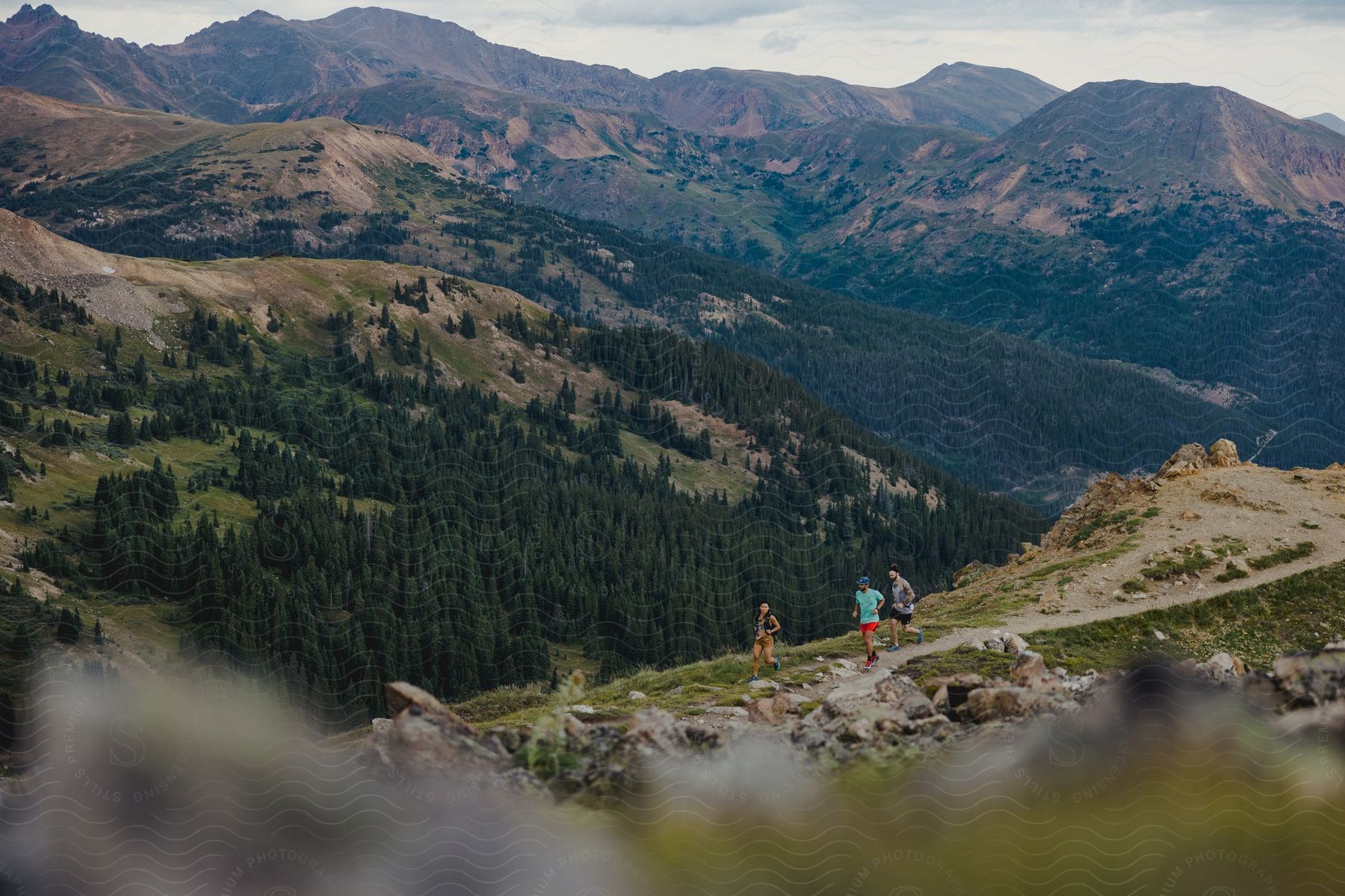 Three people hike down a hill in a canyon