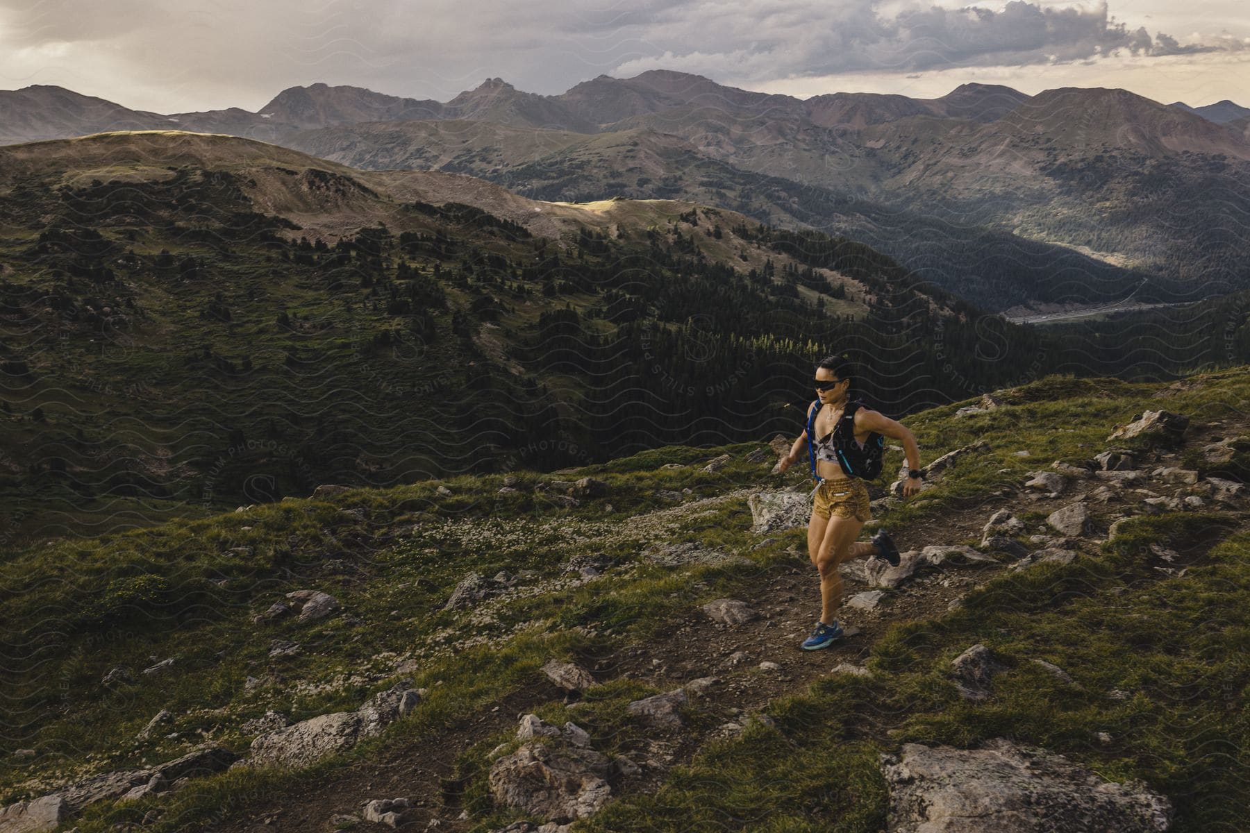 A woman running on a mountain top during dusk or dawn