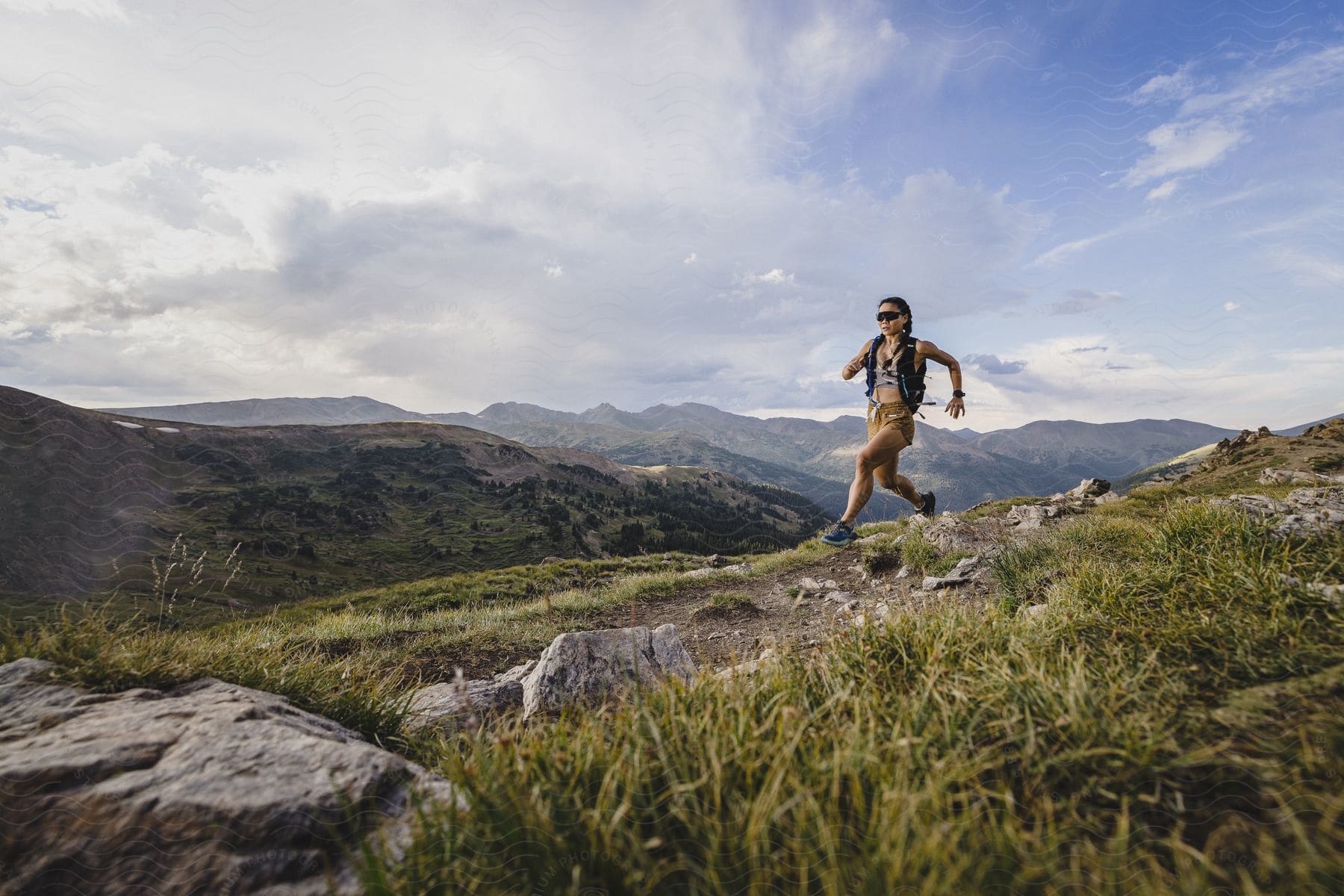 Young fit woman trail running on a mountain during the daytime