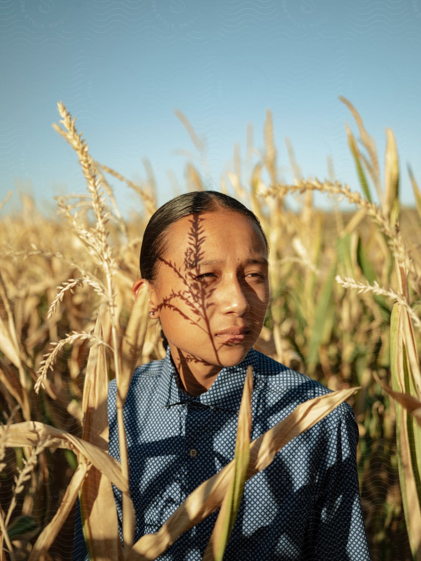 A Teenage Girl Stands In A Wheat Field During The Day