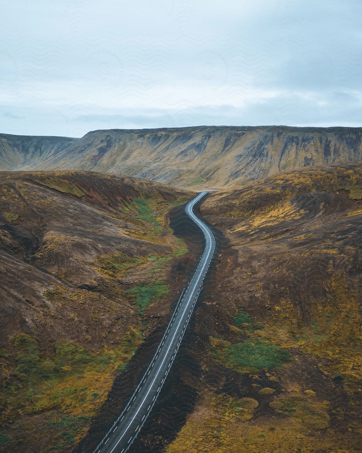 Highway runs through mountain valley with distant mountain