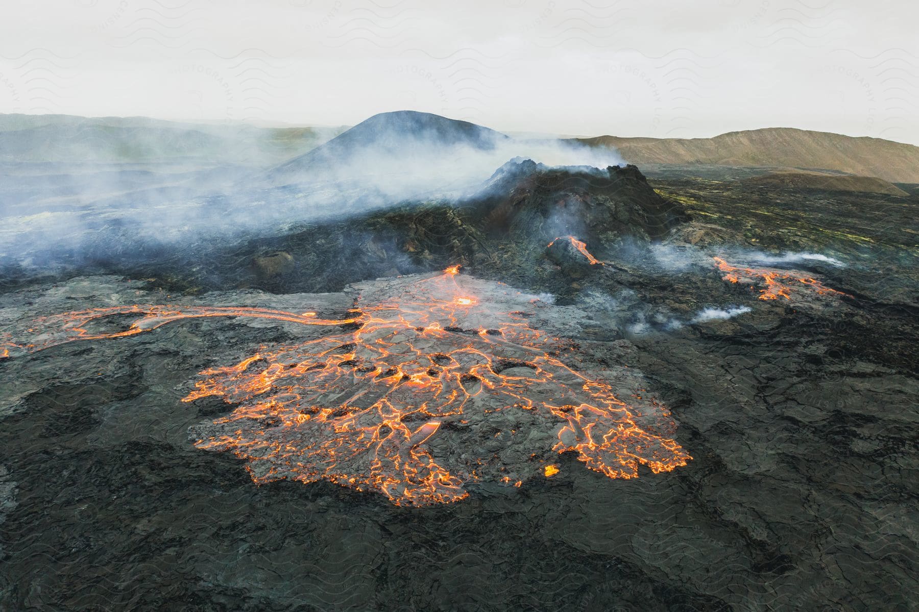 A volcano erupting with a river of hot magma and glowing lava flowing as smoke rises