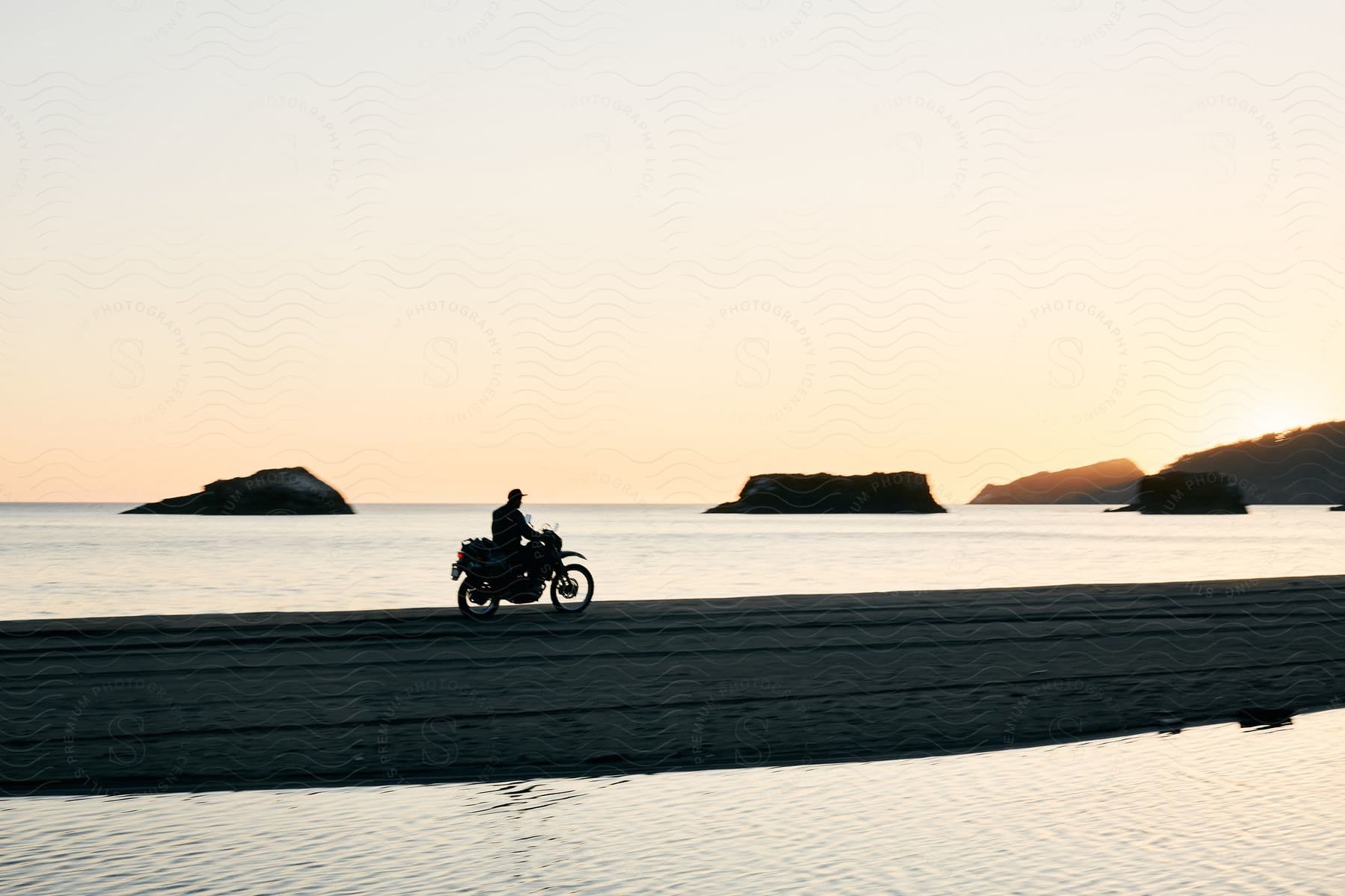 A man rides a motorcycle along a picturesque waterside capturing the spirit of freedom and adventure