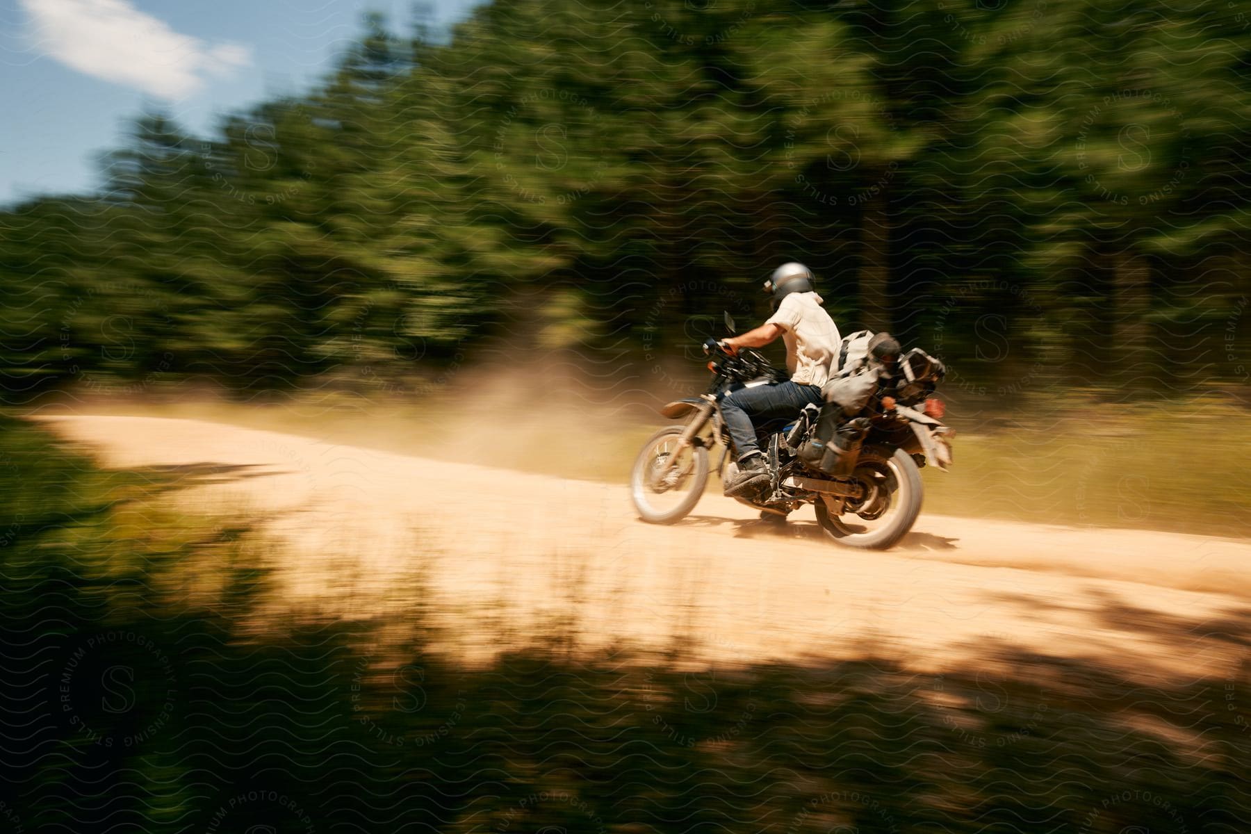 A man on a road trip rides a motorcycle on a rural road during the daytime