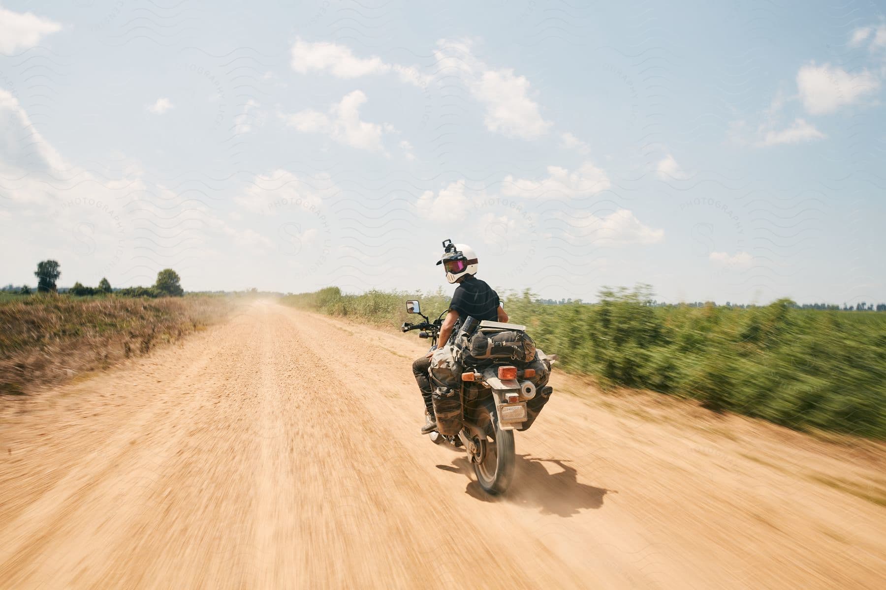 A man riding a motorcycle under an open sky