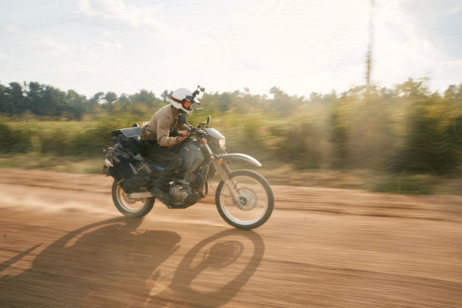 A man riding a motorcycle under an open sky