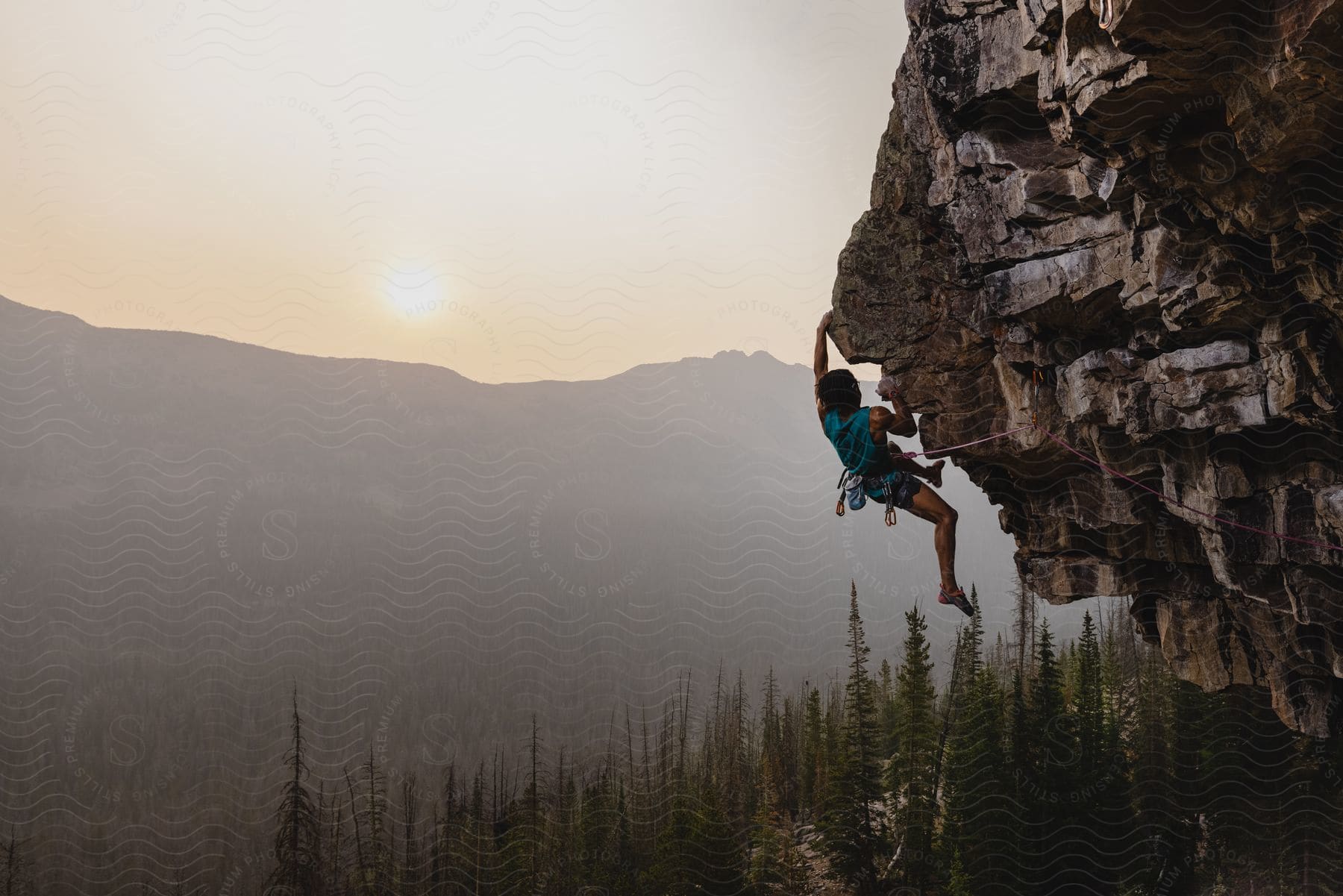 A mountain climber scaling a mountain at dawn