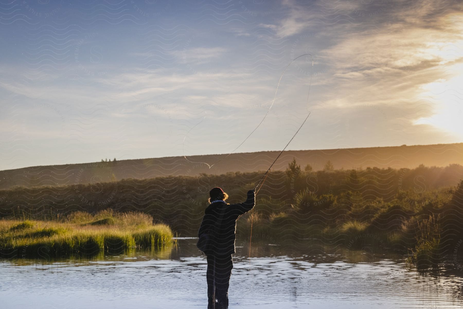 Man peacefully fishing in a river during the early hours of the day in grand tetons