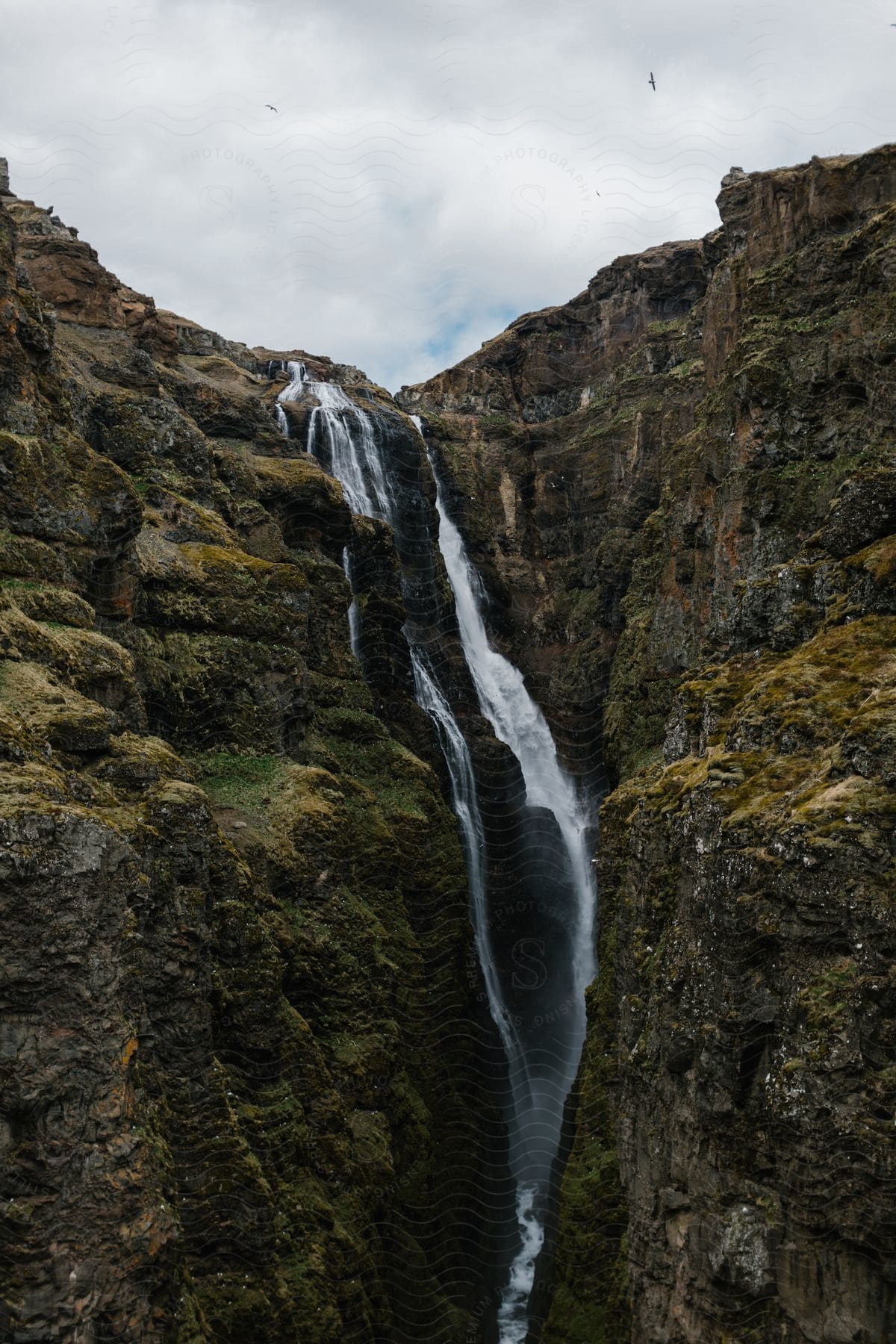 A waterfall flows through a small canyon in iceland