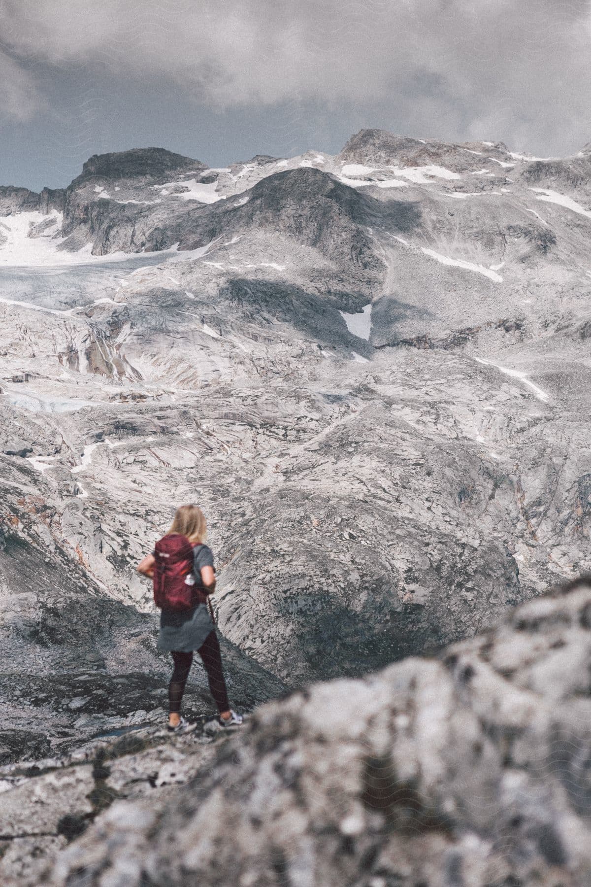 A woman hiking through a mountainous landscape in the alps