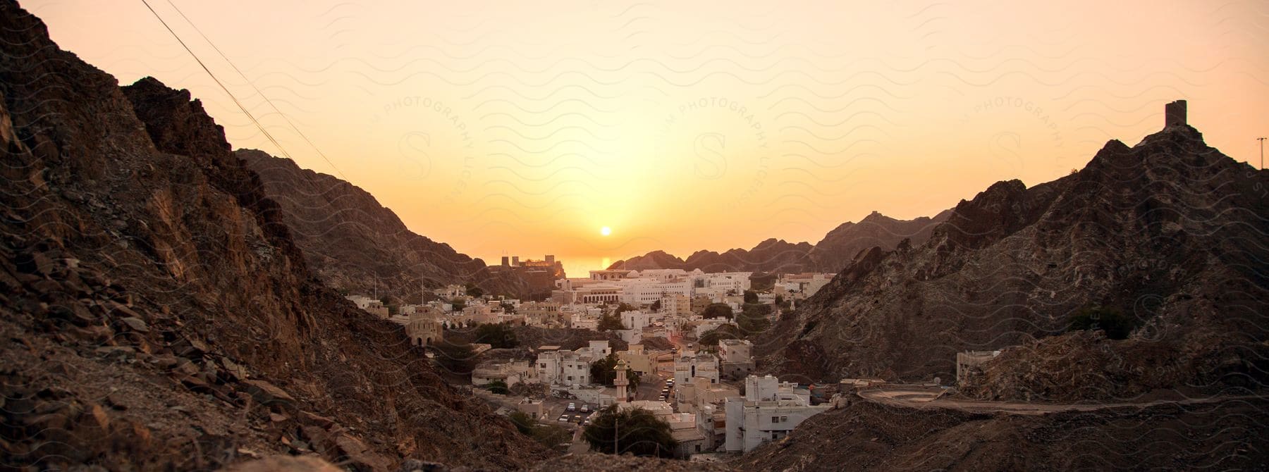 A scenic urban landscape with mountains and buildings at dusk