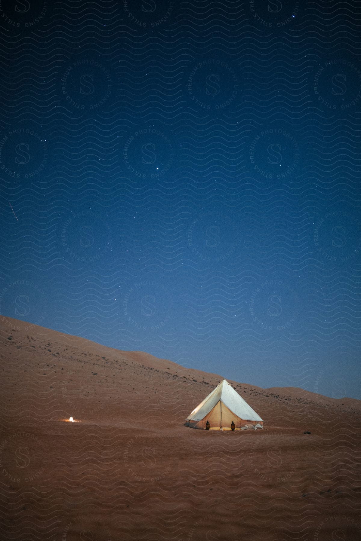 A tent in the desert under a starry night sky