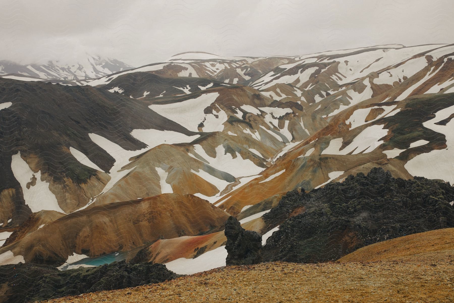 Snowcovered mountains in the distance with a blue lake in the lower left corner