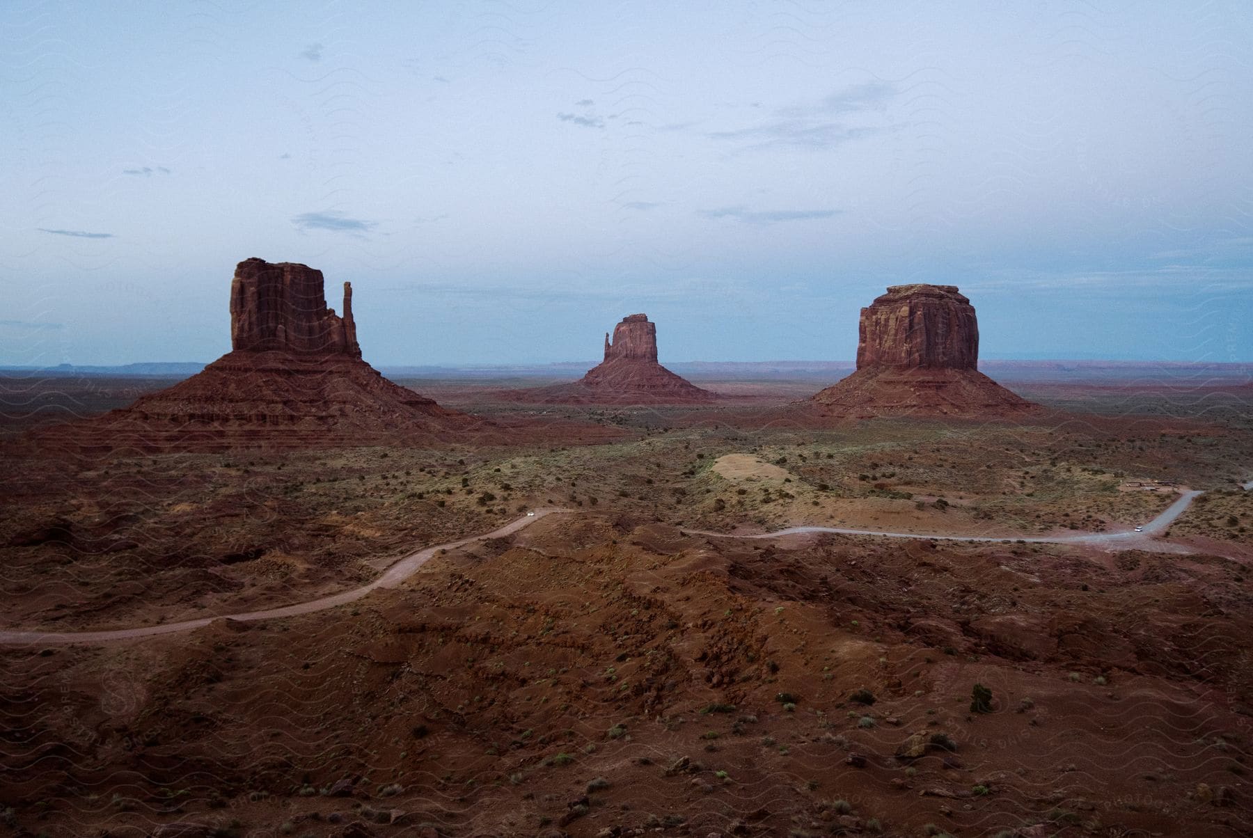 A serene mountain landscape with a brown sky and clouds