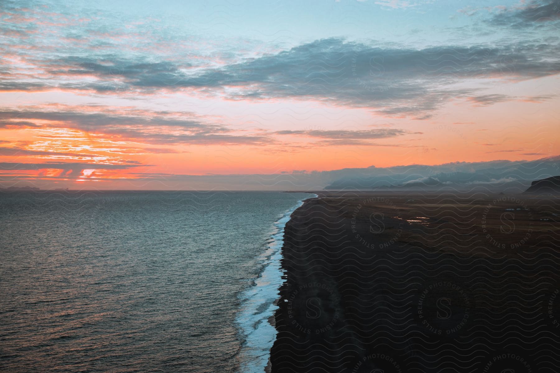 A sunset along the coast with a red sky at dawn