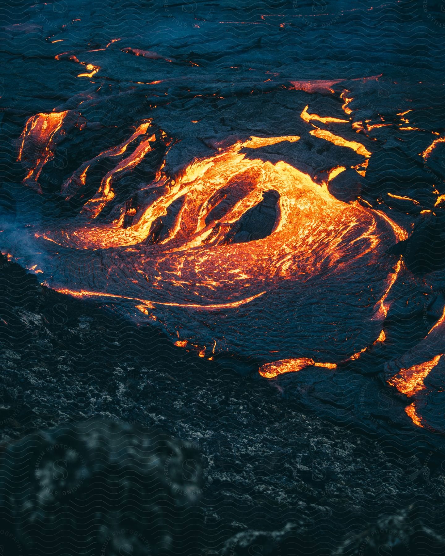 Lava spreads through the top of a volcano in iceland at night