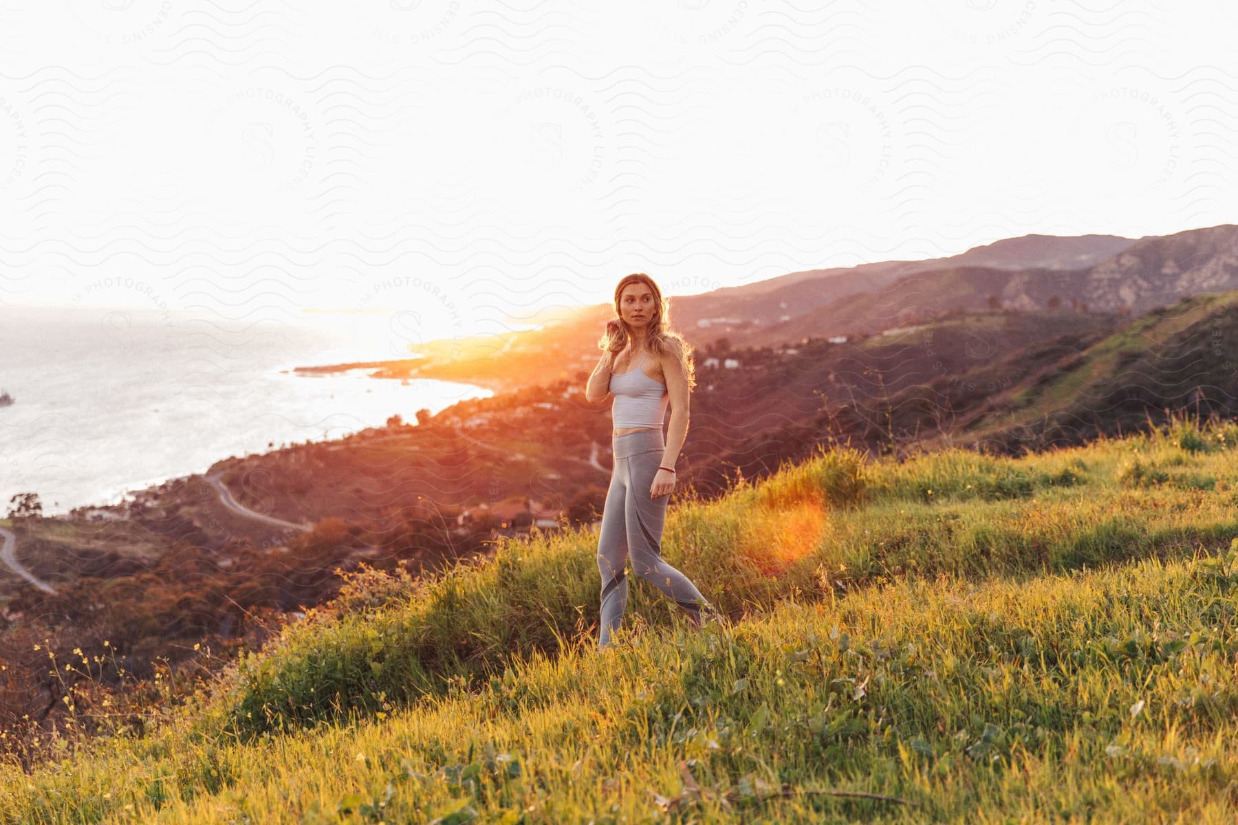 Blonde woman walking outdoors next to the shore