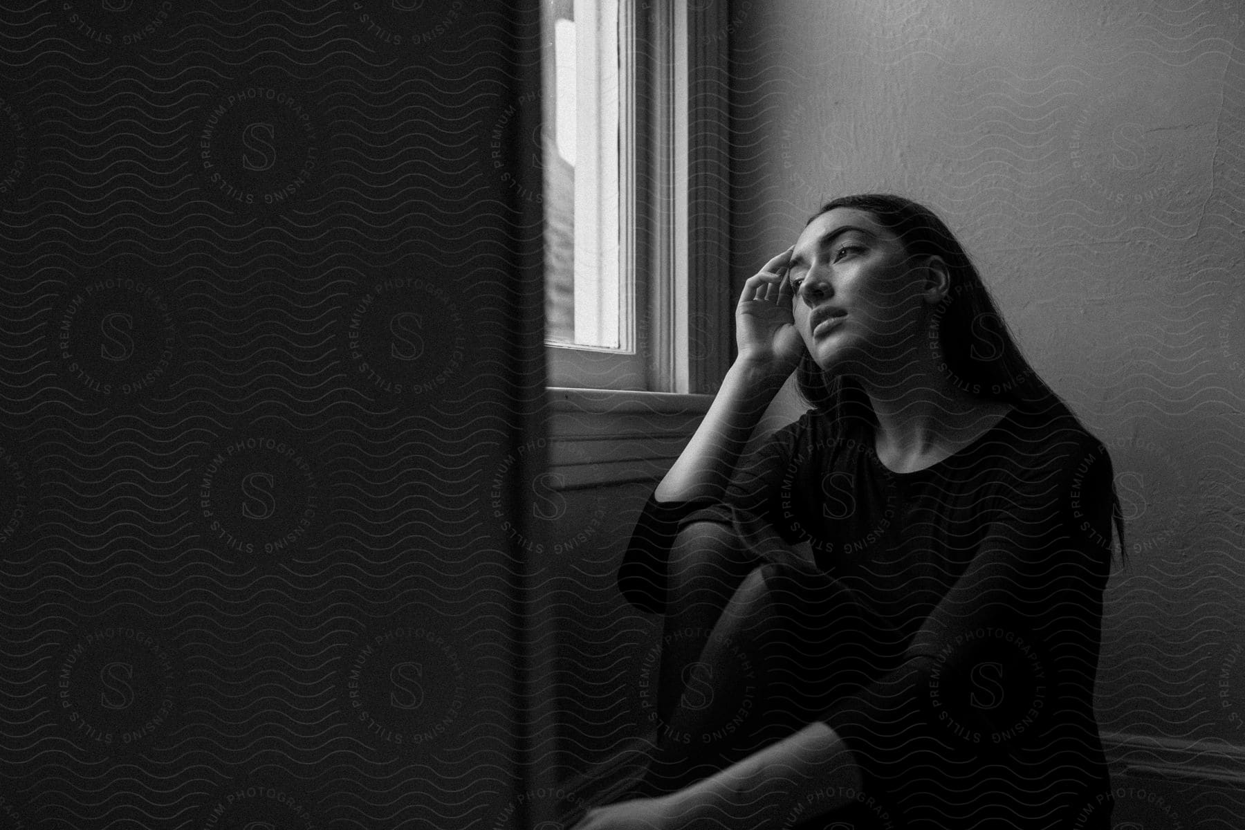 A young white woman sitting inside her home