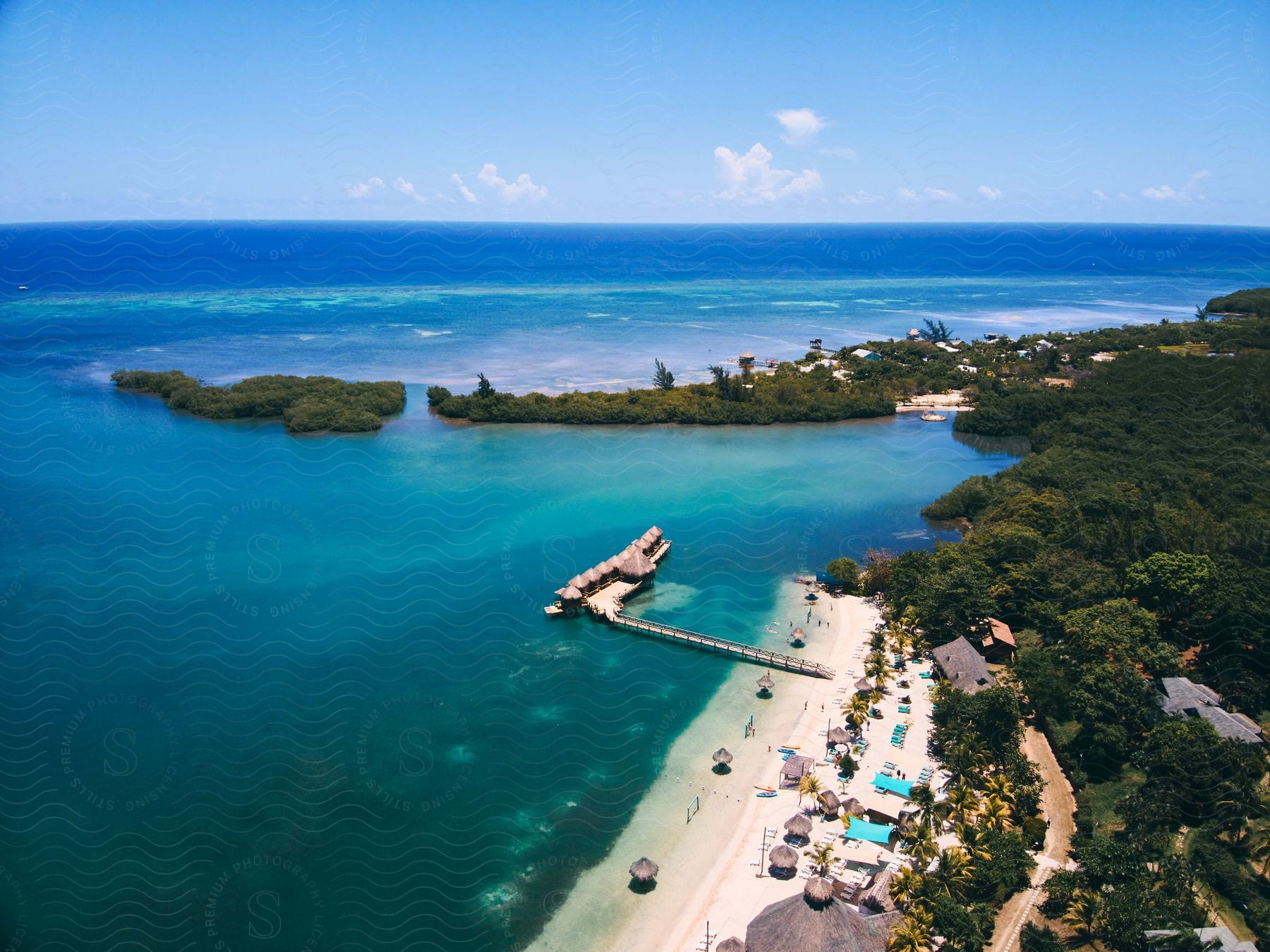 Aerial view of a beach on an island with clear blue water and a shoreline