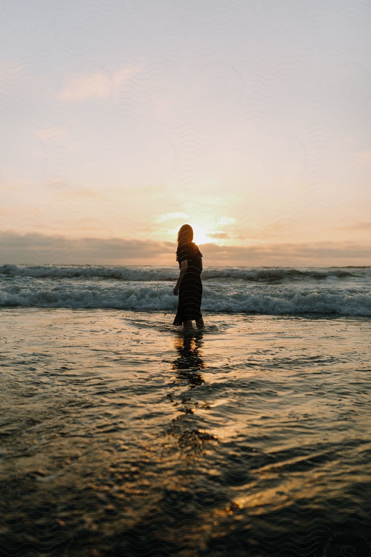 A young woman standing in the middle of the ocean during the day