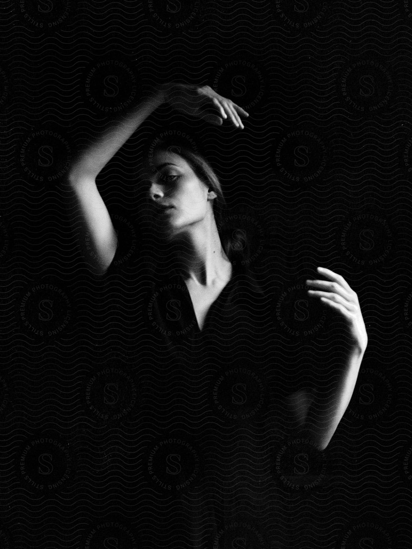 Woman gesturing with her arms against a dark background