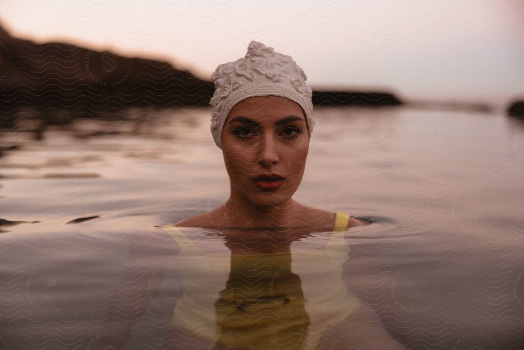 Woman in yellow bathing suit and cap bathing outdoors