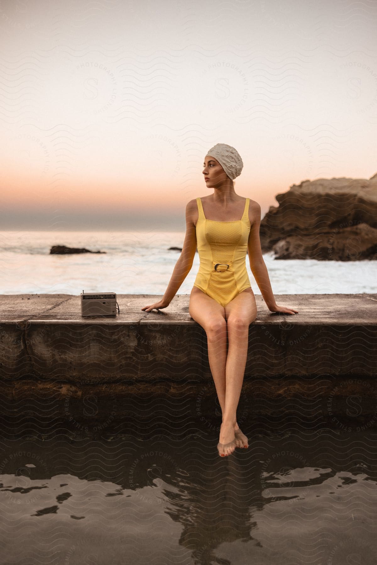 A woman sitting on a beach by the water