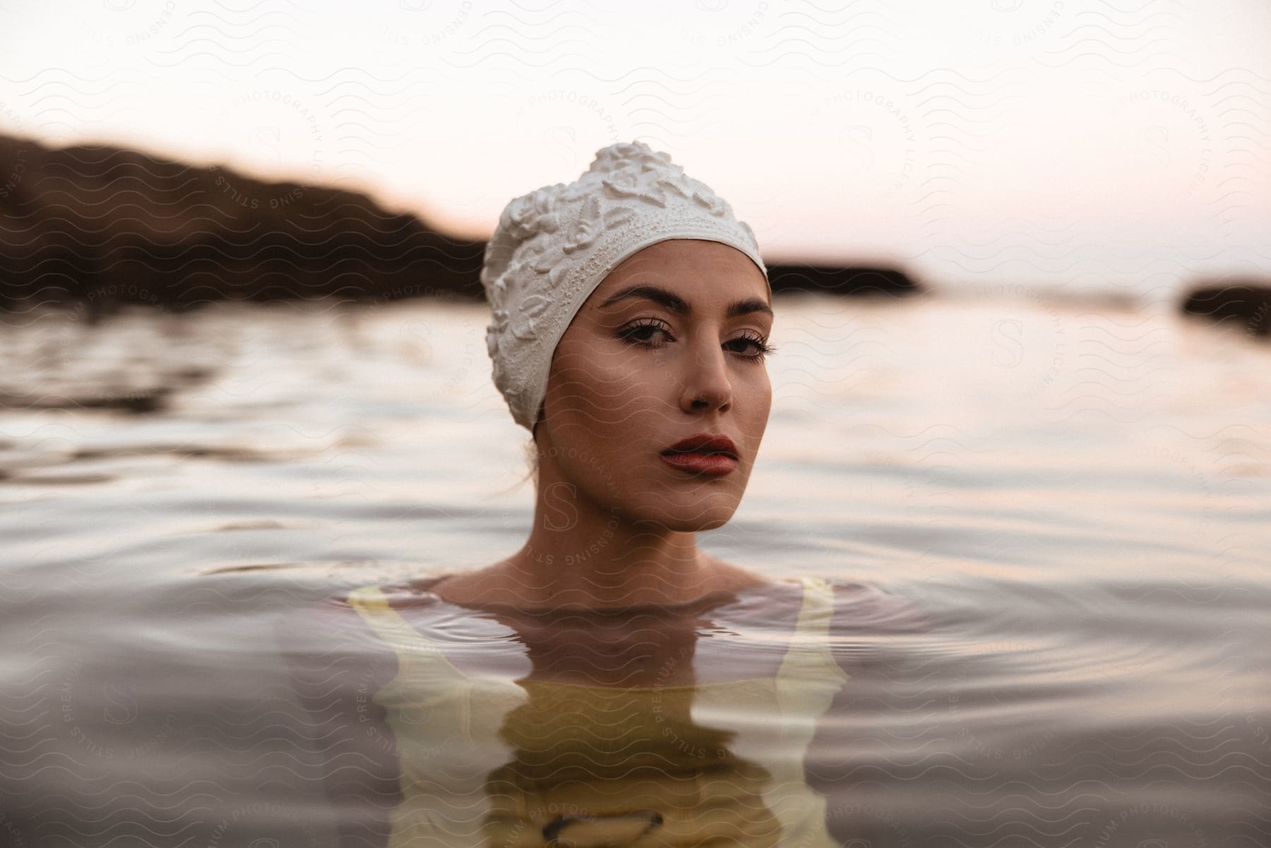 Woman relaxing in calm water with a hill in the background