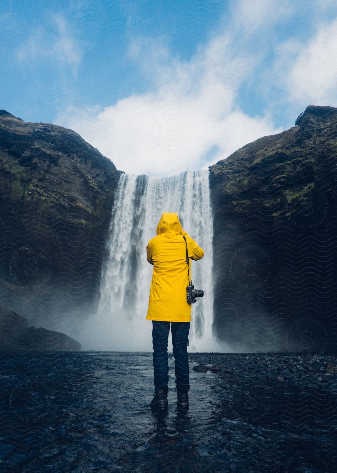 A nature scene in iceland with mountains a lake and a waterfall no people are present