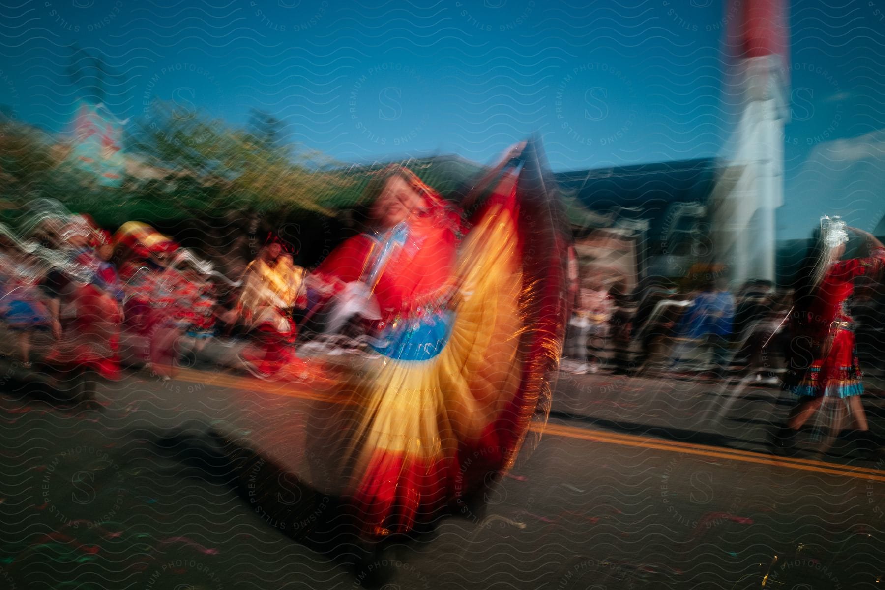 A woman in a colorful dress dances in the street