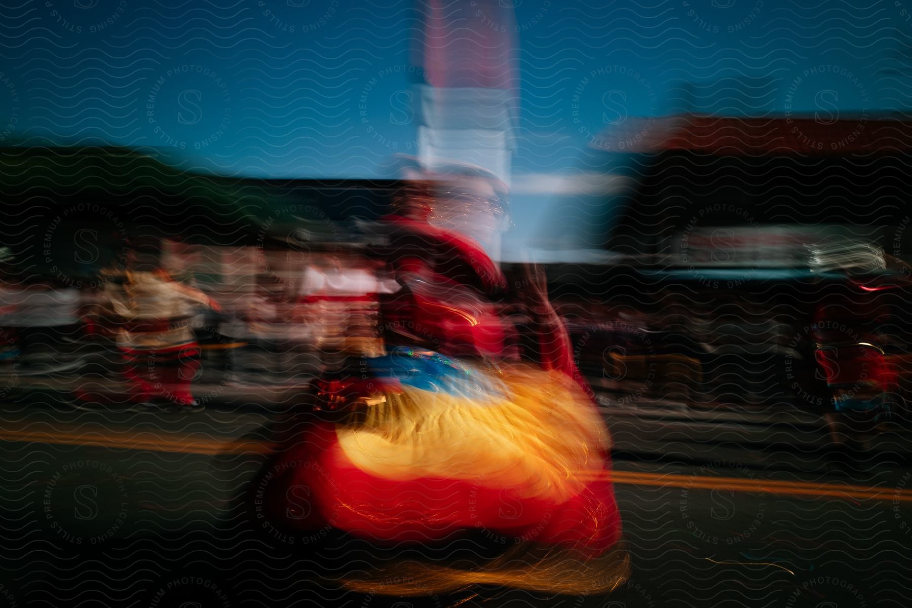 A person in costume dancing on a street at night