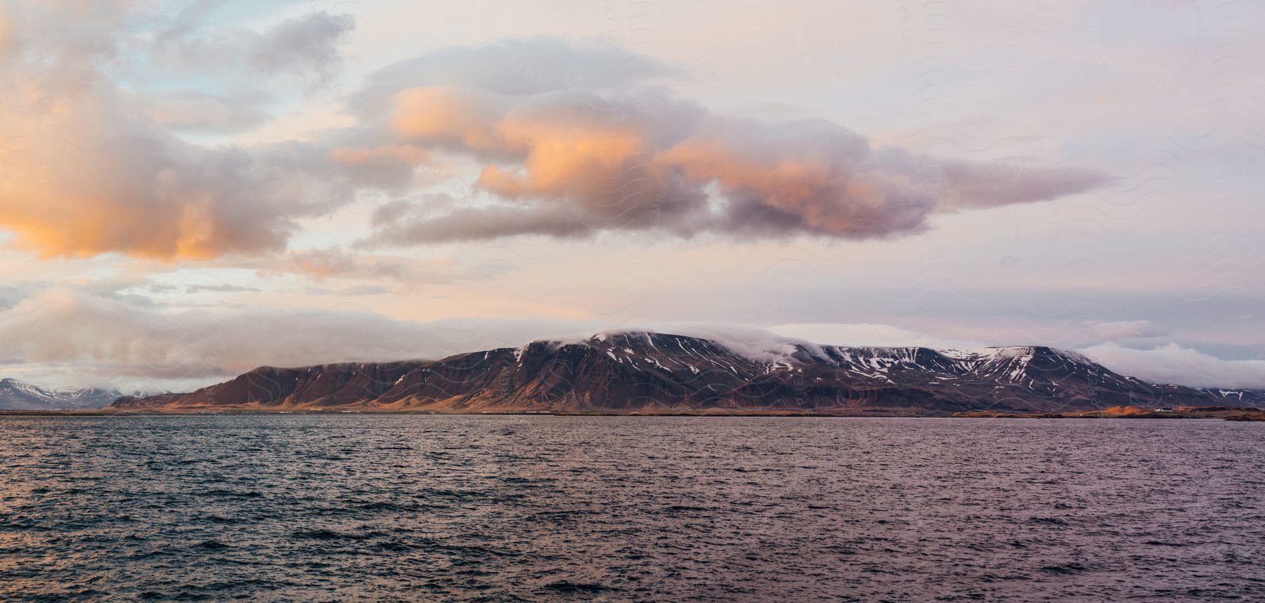 A serene landscape with a lake mountains and a cloudy sky