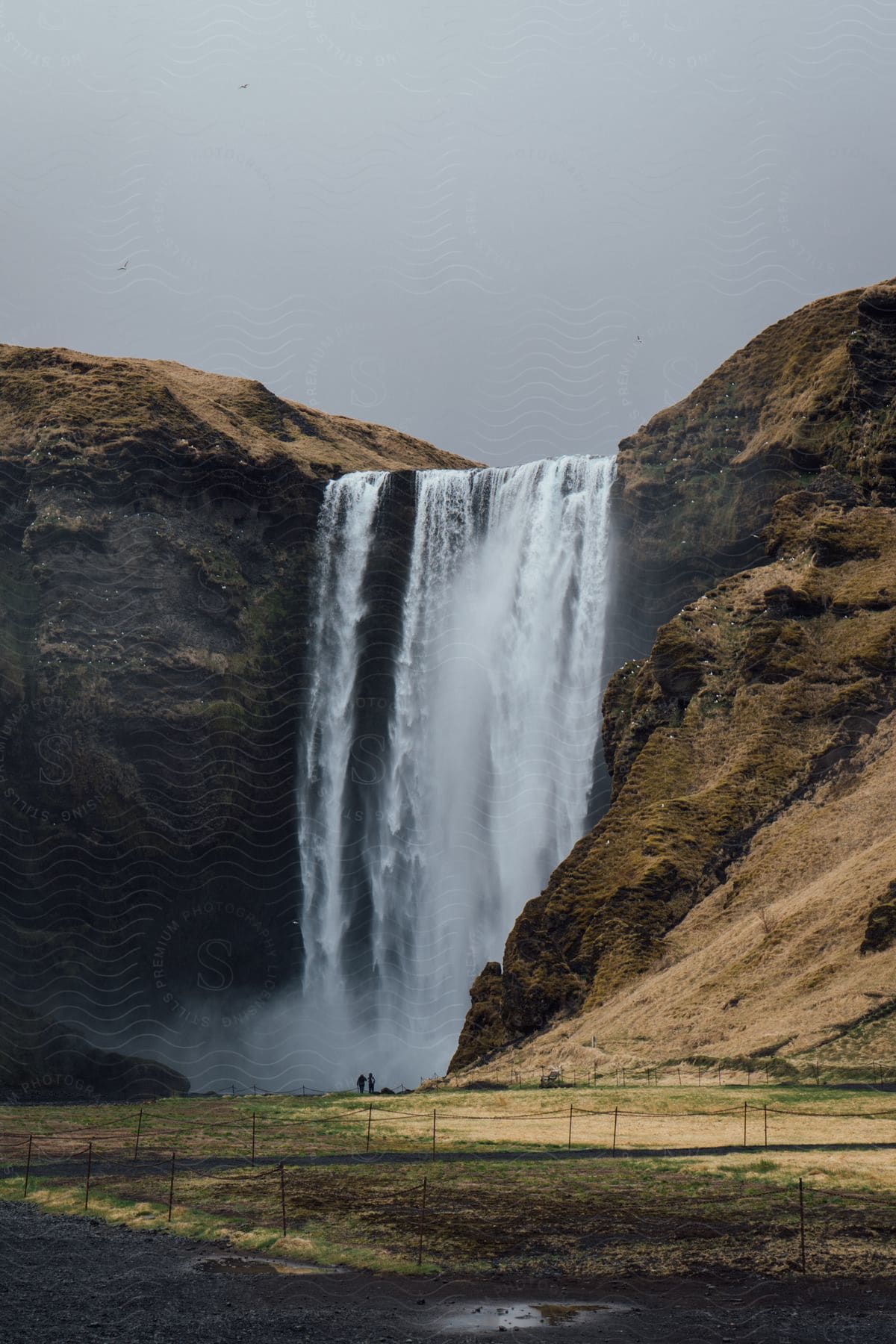 A large waterfall cascades over a cliff to the ground below