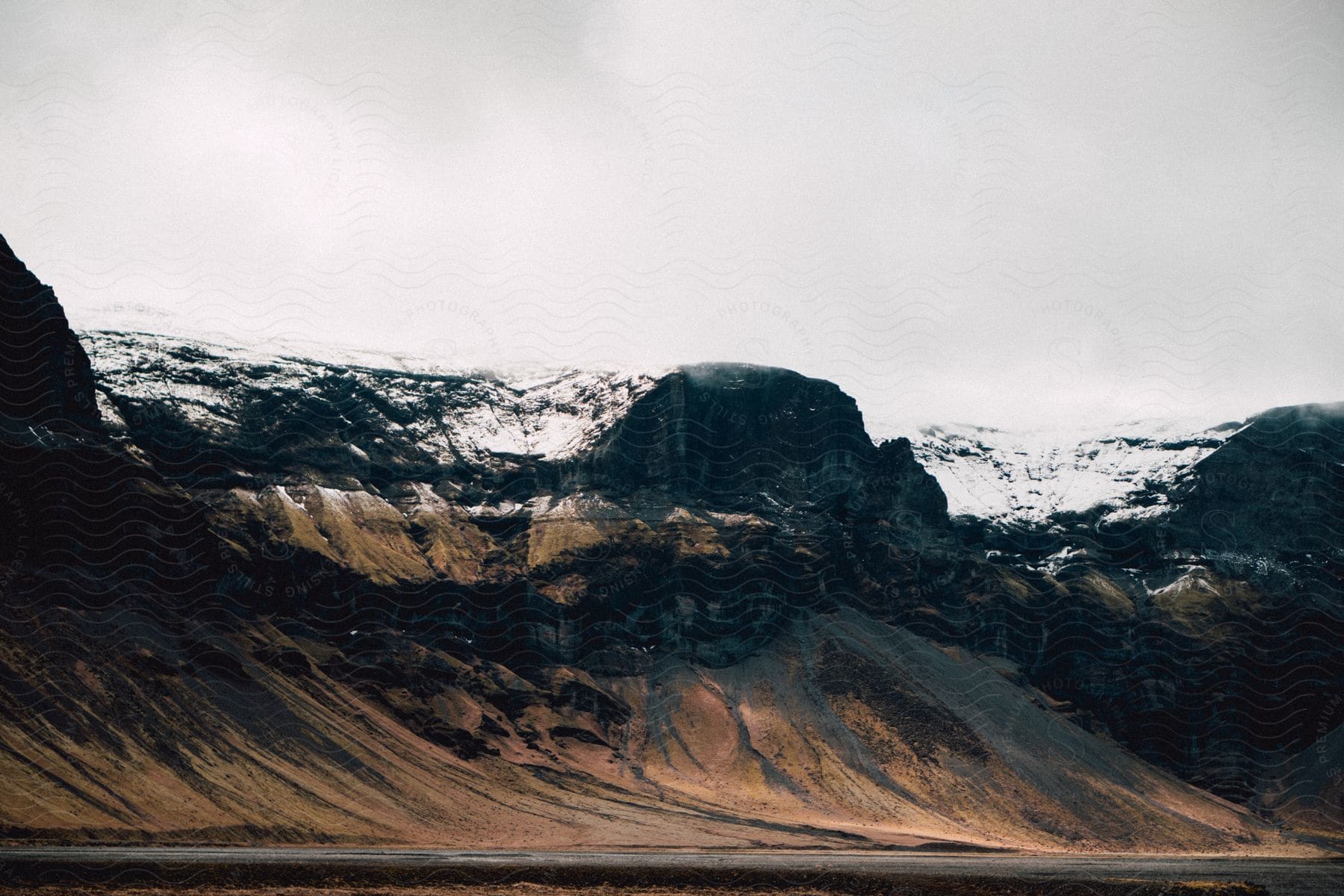 A serene mountain landscape covered in snow and surrounded by clouds