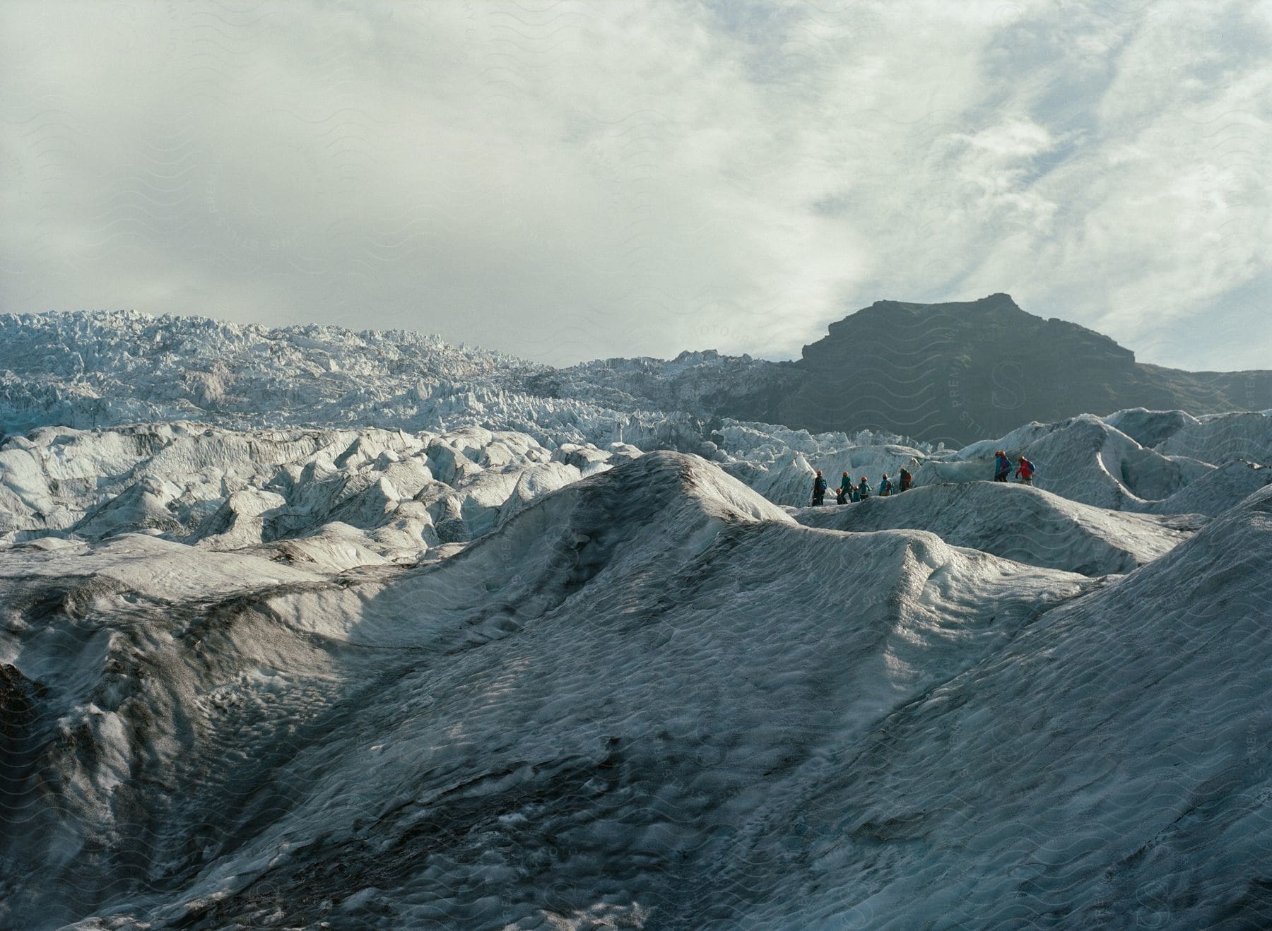 A group of eight people crossing a frozen landscape in iceland