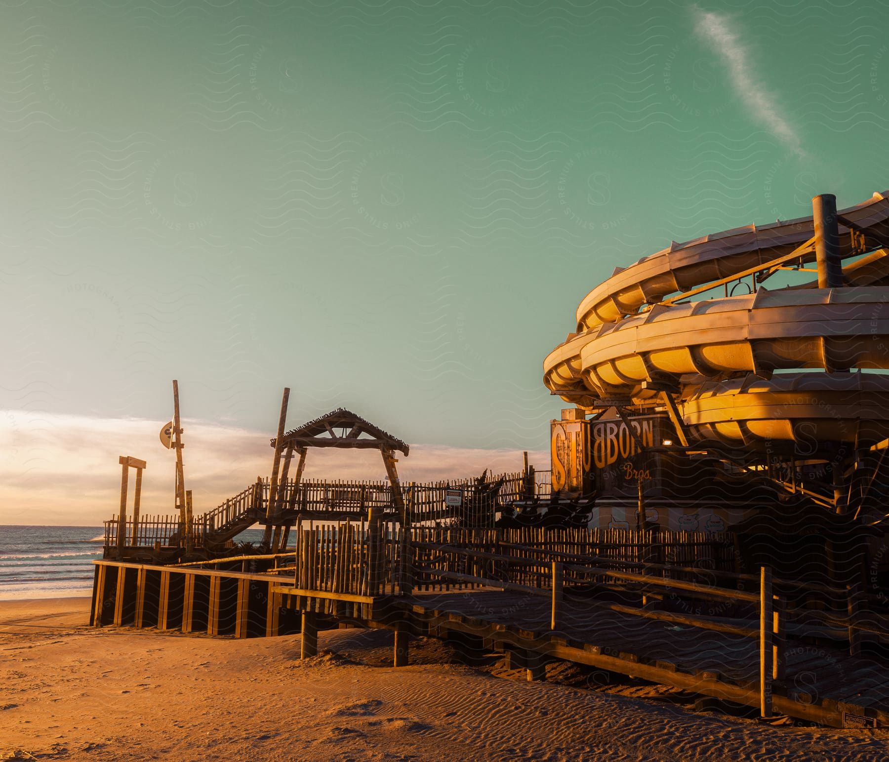 The structure of a closed summer playground at sunset built on the beach