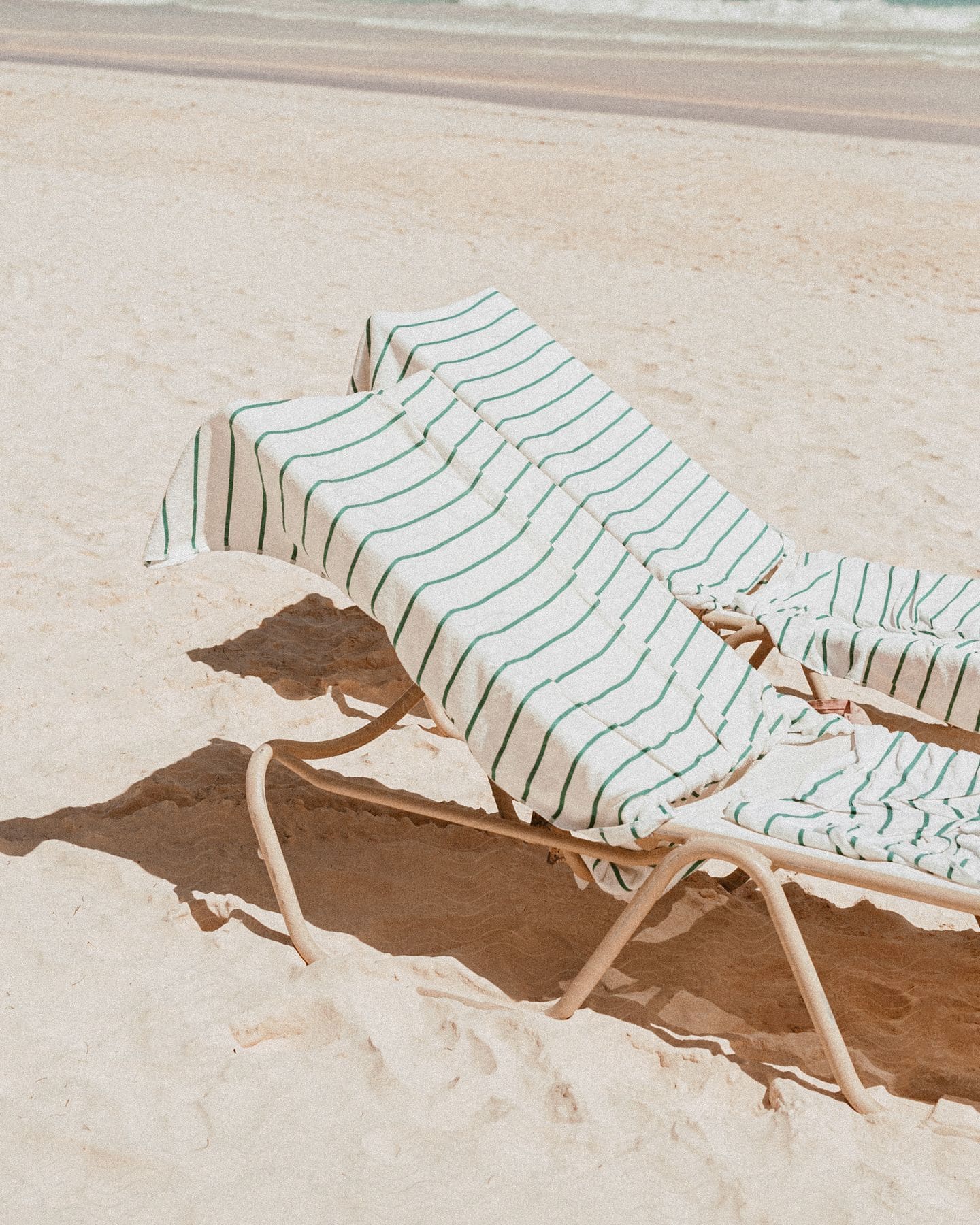 Two beach chairs covered in towels on the beach